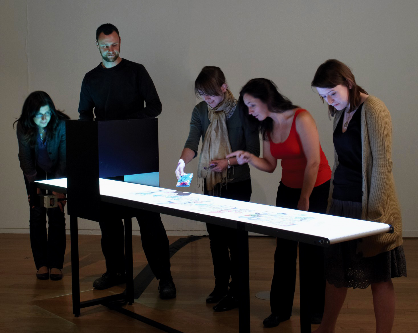 Several people interacting with a digital artwork.