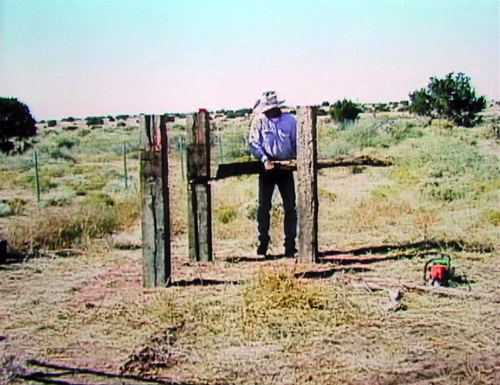 Video still of a man setting posts into the ground