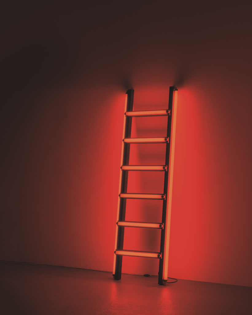 A ladder constructed of red fluorescent light bulbs.