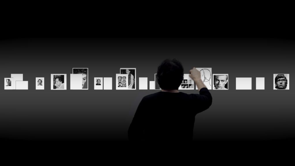 El Coleccionista (The Collector) is a video projection of the artist placing virtual photographs on real pieces of paper on a custom-built shelf or ledge wall.
