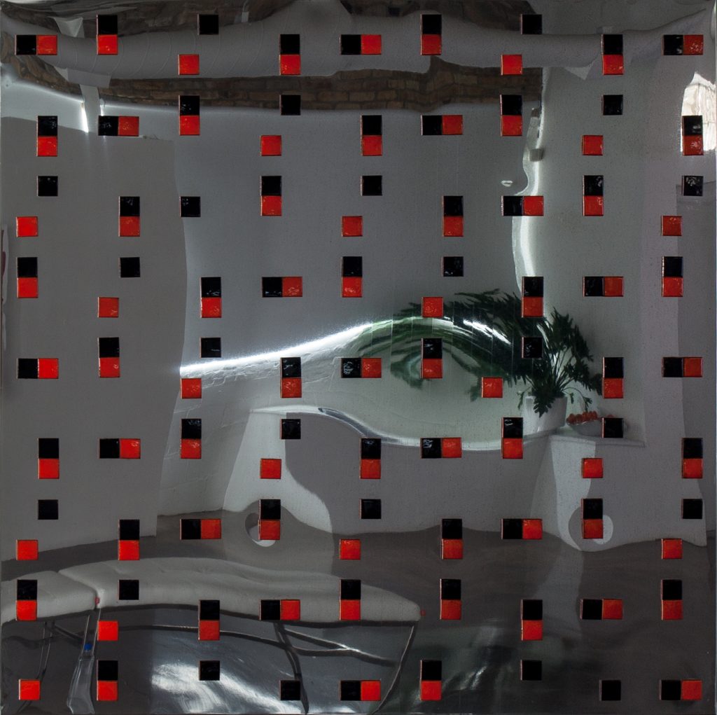 An artwork with black and red enameled squares mounted on a polished steel surface