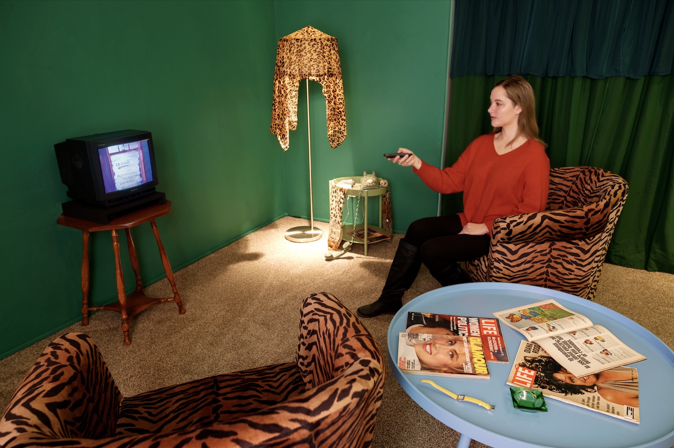 Installation featuring living room props and an interactive video.