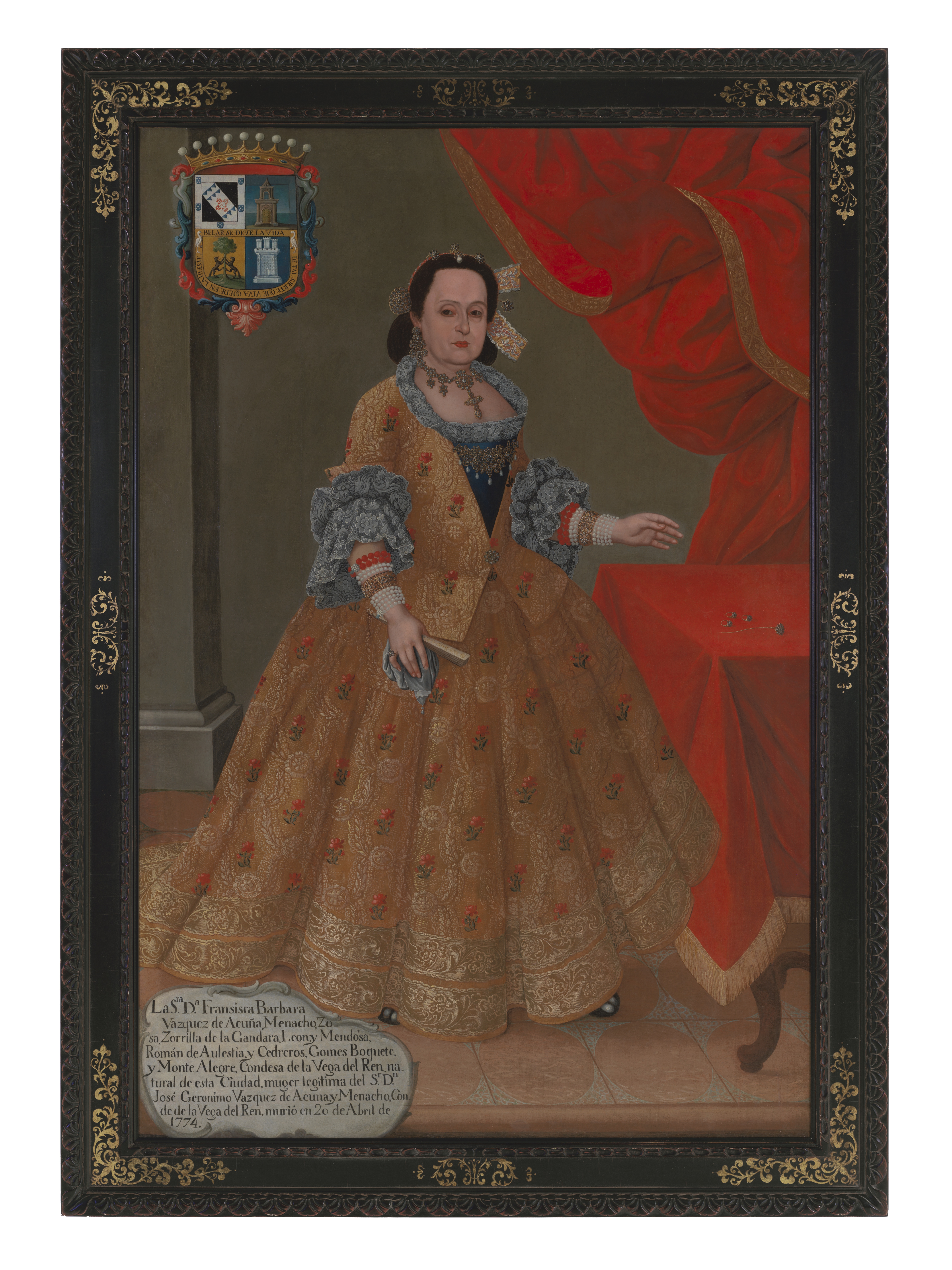 A painting depicting a woman in an opulent brocade dress in front of a table and wall draped in red fabric. Her coat of arms is at the top left corner and a cartouche with her biography is in the bottom left.